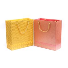 two different colored bags with gold handles and handles, one pink and the other yellow