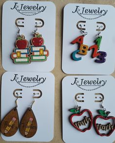 four pairs of wooden earrings with the words jewelry and an apple on each earring