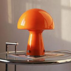 an orange lamp sitting on top of a glass table