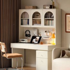 a laptop computer sitting on top of a white desk next to a chair and window