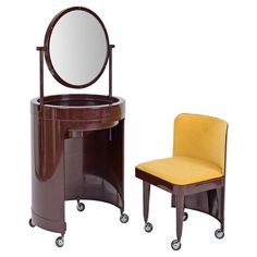 a chair and vanity with a round mirror on it's stand next to each other