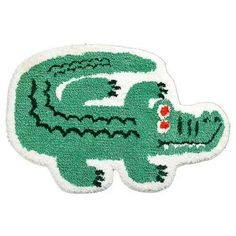 a green and white rug with an alligator design on the front, it's head is