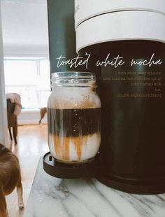 there is a jar with liquid in it on the counter next to a coffee maker