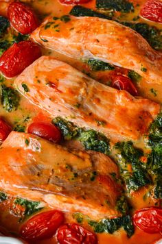 baked salmon with tomatoes and spinach in a white casserole dish, ready to be eaten