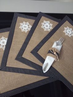 four placemats with white doily on them are sitting next to a fork and napkin