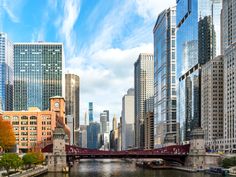 a river running through a city with tall buildings on both sides and a bridge in the middle