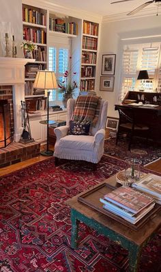 a living room filled with furniture and a fire place next to a book shelf full of books