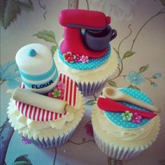 three cupcakes with frosting and fondant decorations are arranged on top of each other