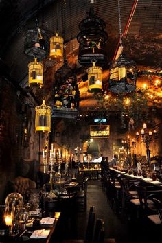 a restaurant with several birdcages hanging from the ceiling