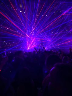 people are standing in the dark with their hands up and laser lights shining down on them