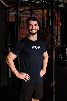 a man standing in front of a bar with his hands on his hips and smiling