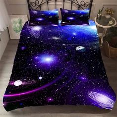 a bed with purple and blue space themed comforter covers on top of the bed