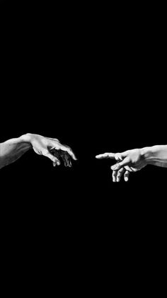 two hands reaching out towards each other in black and white, against a dark background