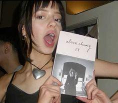 a woman holding up an album with the words alon chuy it in front of her face