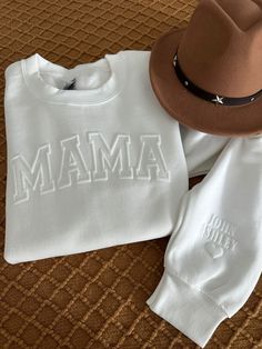 a hat, sweatshirt and pants sitting on top of a bed