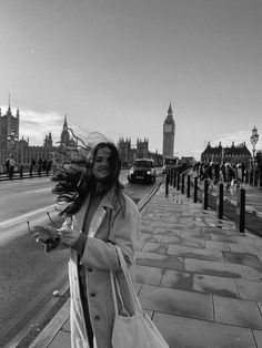 a woman is walking down the street with her hair blowing in the wind