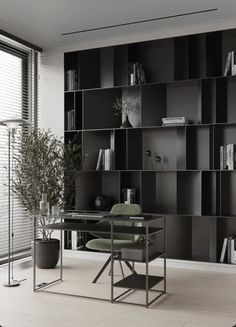 a black and white photo of an office with bookshelves on the back wall