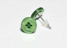 a pair of green buttons sitting on top of a white table