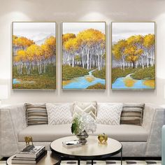 three paintings are hanging on the wall in a living room