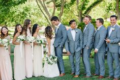 a group of people standing next to each other on top of a grass covered field