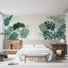 a bed sitting in a bedroom next to a wall with green leaves on it's side