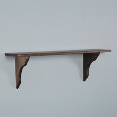 a wooden shelf mounted to the side of a wall with two shelves on each side