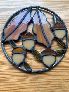 a circular stained glass piece sitting on top of a wooden table