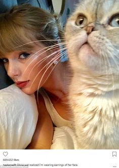 a woman laying on top of a bed next to a white cat with blue eyes