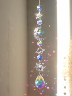 the sun shines brightly in front of a window with an ornament hanging from it