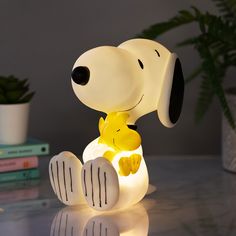 a snoopy lamp sitting on top of a table next to a christmas tree