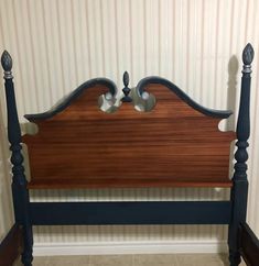 a wooden headboard sitting on top of a tiled floor next to a white wall