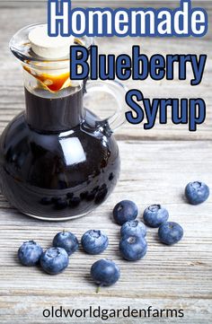 homemade blueberry syrup in a glass bottle with fresh blueberries around it and the words, homemade blueberry syrup