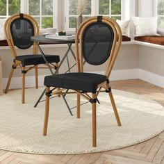 two chairs sitting on top of a rug in front of a dining room table and window