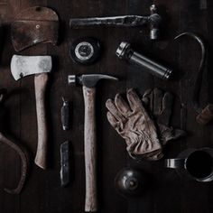 several different types of tools laid out on a wooden table with leather gloves and other items