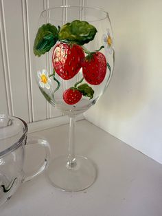 a wine glass with strawberries painted on it