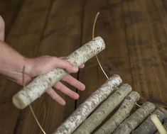 a hand is holding a piece of wood