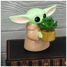 a baby yoda planter sitting on top of a book