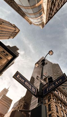 looking up at street signs and skyscrapers in new york city, ny on east 10th st