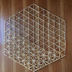 a wooden table topped with a metal hexagonal object on top of a hard wood floor