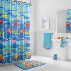 a bathroom decorated in blue and orange with fish on the shower curtain next to the sink