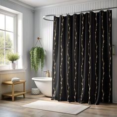 a white bath tub sitting next to a black shower curtain in a bathroom under a window