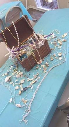 a table topped with a trunk filled with pearls and other things on top of it