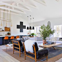 a living room filled with furniture and a cross on the wall in the middle of the room