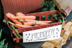 a red basket filled with carrots sitting on top of a table