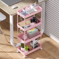 a computer desk with pink shelving unit in front of it