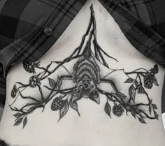 a black and white photo of a woman's lower back tattoo with flowers on it