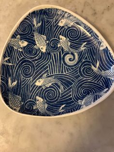 a blue and white bowl with fish on it