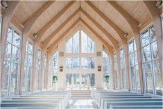 the inside of a church with rows of pews in front of large glass windows