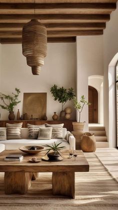 a living room filled with lots of furniture and plants on top of a wooden table