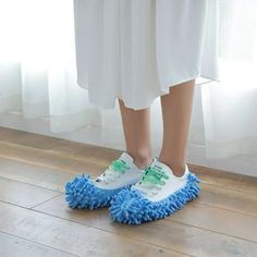 a pair of feet in white shoes with blue mop